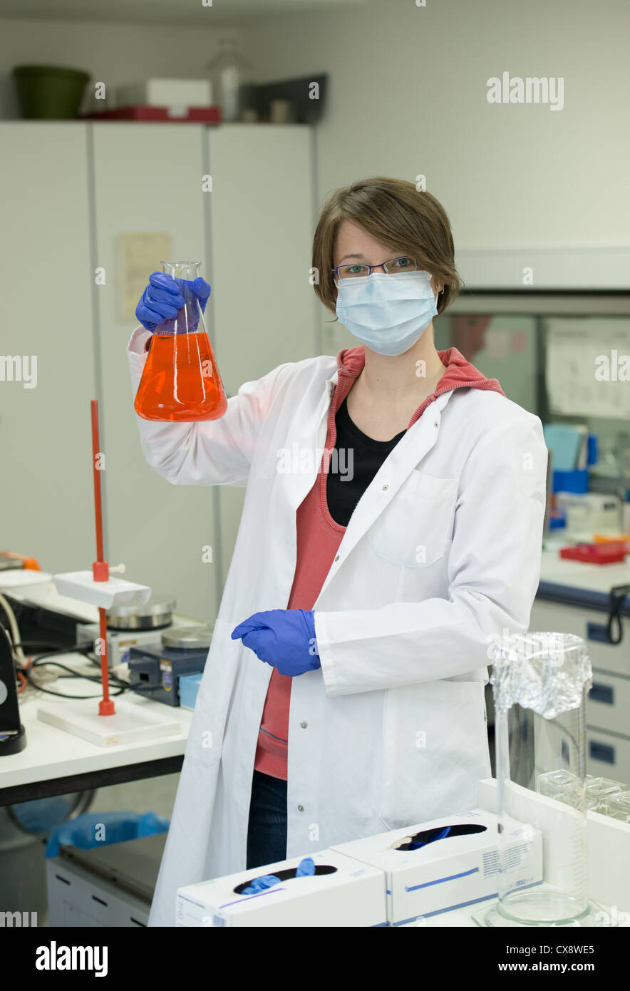 Giovane donna preparare soluzioni in laboratorio Foto Stock