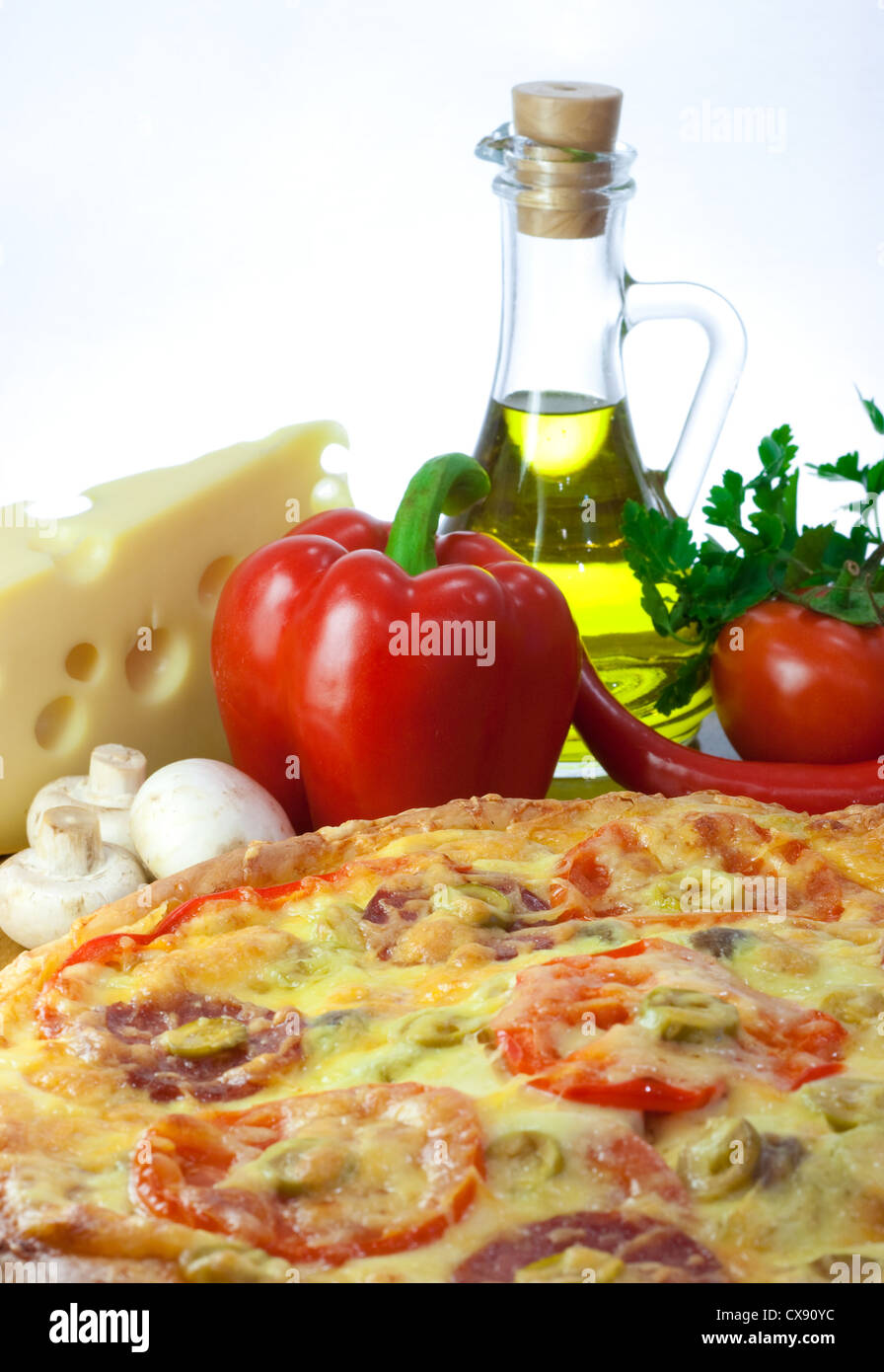 Pizza e ingredienti: pepe, olio d'oliva, formaggi, funghi, pomodori Foto Stock