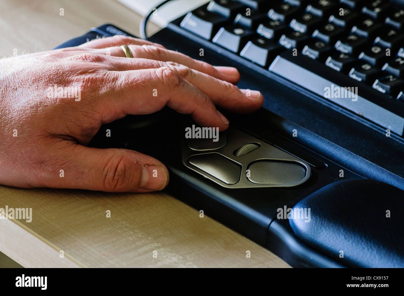 L'uomo utilizza un RollerMouse Pro2 ergonomico mouse del computer per persone con problemi di polso Foto Stock