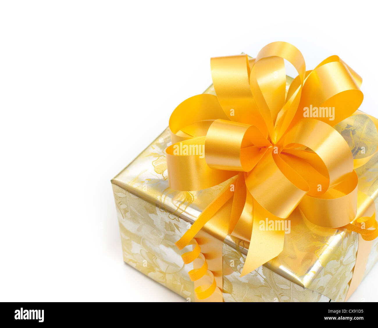 Bel regalo confezionato in carta oro con prua giallo su sfondo bianco Foto Stock