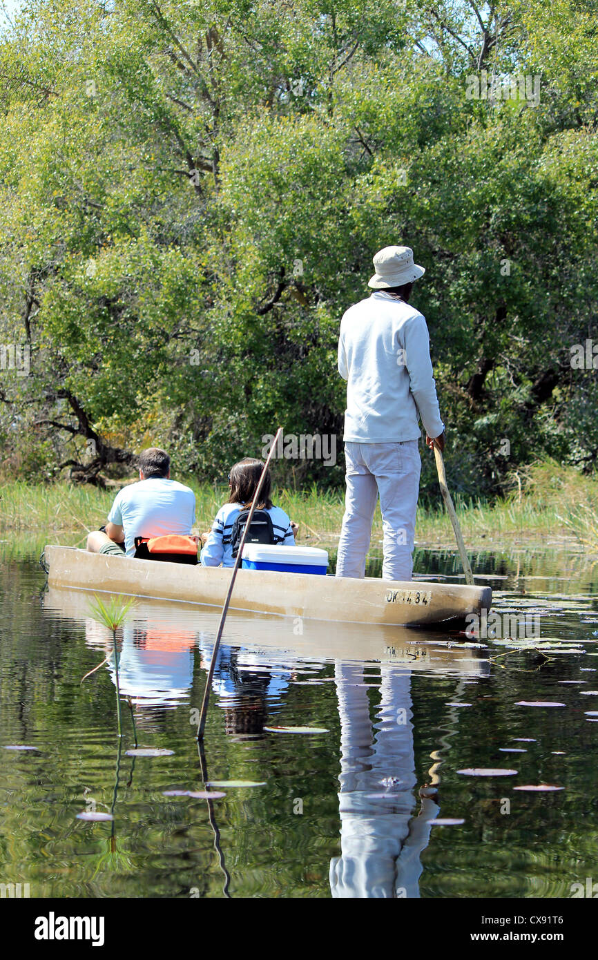 La corsa in un tradizionale Okavango Delta mokoro canoa, attraverso il reed coperta d'acqua. A nord del Botswana. Foto Stock