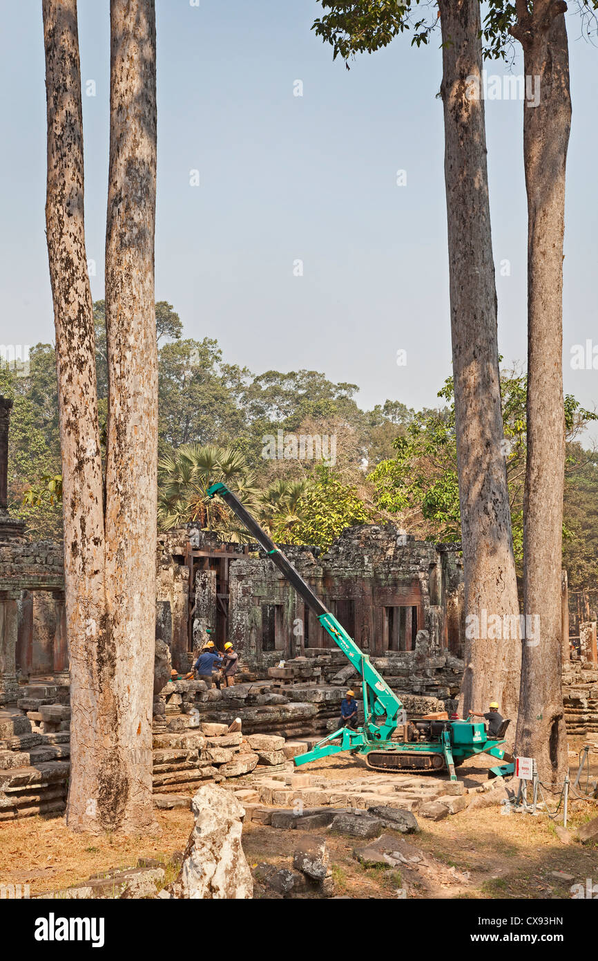 Giapponese Angkor progetto di conservazione, i lavoratori che maneggiano pietre con una gru. Foto Stock