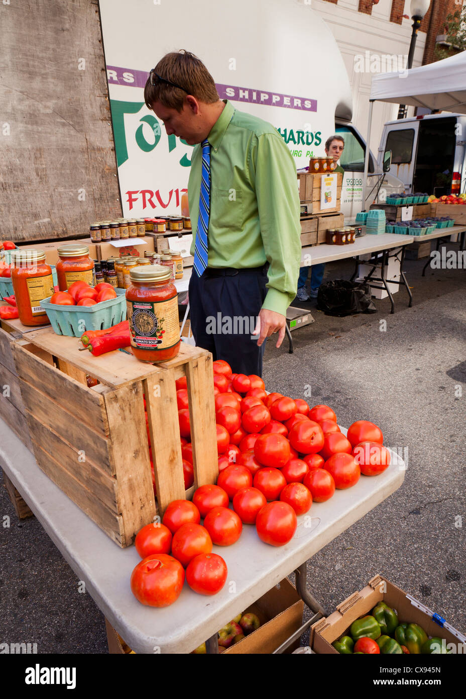 Uomo di ispezionare i pomodori al mercato degli agricoltori - Washington DC, Stati Uniti d'America Foto Stock