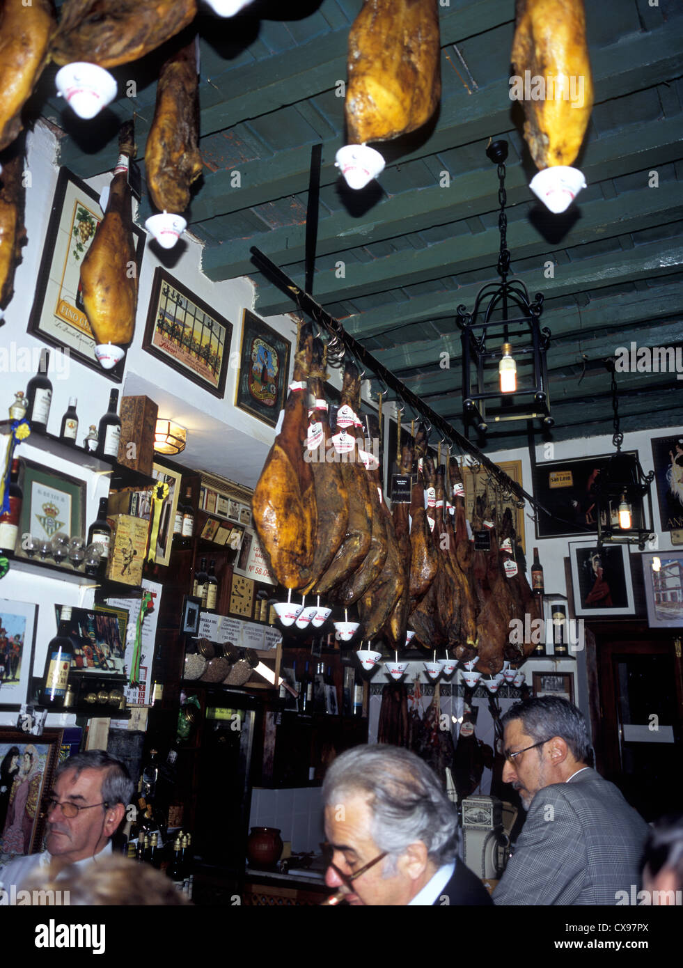 Spagna, Andalusia Siviglia, street cafe intorno al Barrio de Santa Cruz, interno con carni appese. Foto Stock