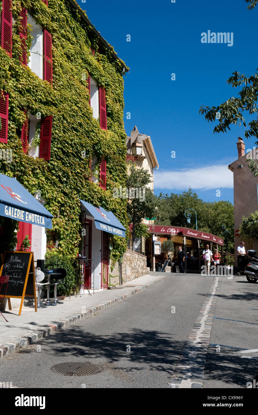 Una vista lungo Boulavard des Aliziers mostra un edera edificio coperto in uso come un ristorante e di un bar in un villaggio francese Foto Stock