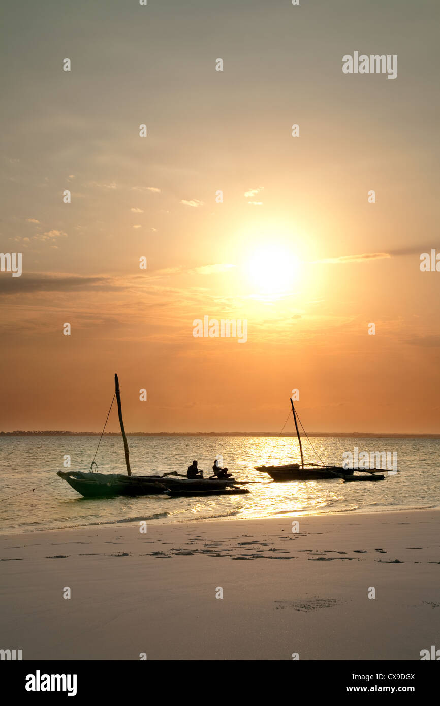 Due dhow tradizionale ormeggiata sulla spiaggia al tramonto, Michamwi, Zanzibar Africa Foto Stock