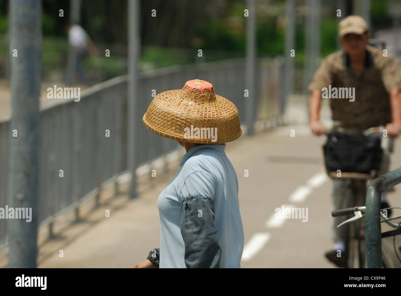 Donna cinese indossando il tradizionale intessute bamboo hat. Foto Stock