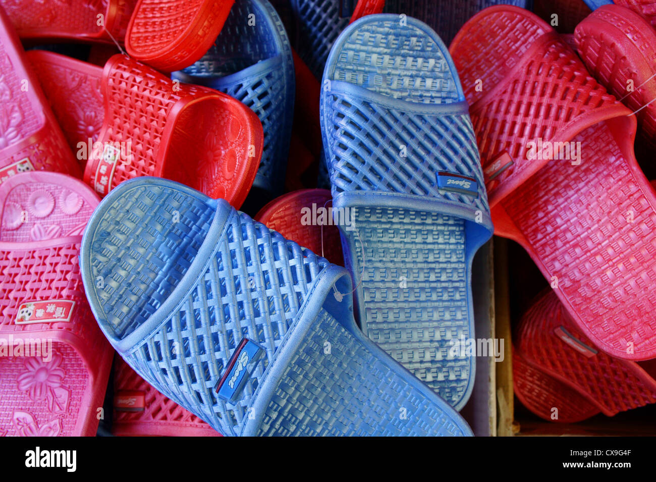 Rosso, rosa e blu in plastica slip-on Sandals in vendita in Chinatown, Vancouver, British Columbia, Canada Foto Stock