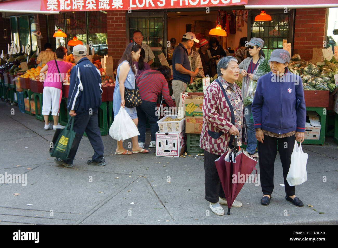 Due anziani le donne cinesi al di fuori di un produrre store, Chinatown, Vancouver, British Columbia, Canada Foto Stock
