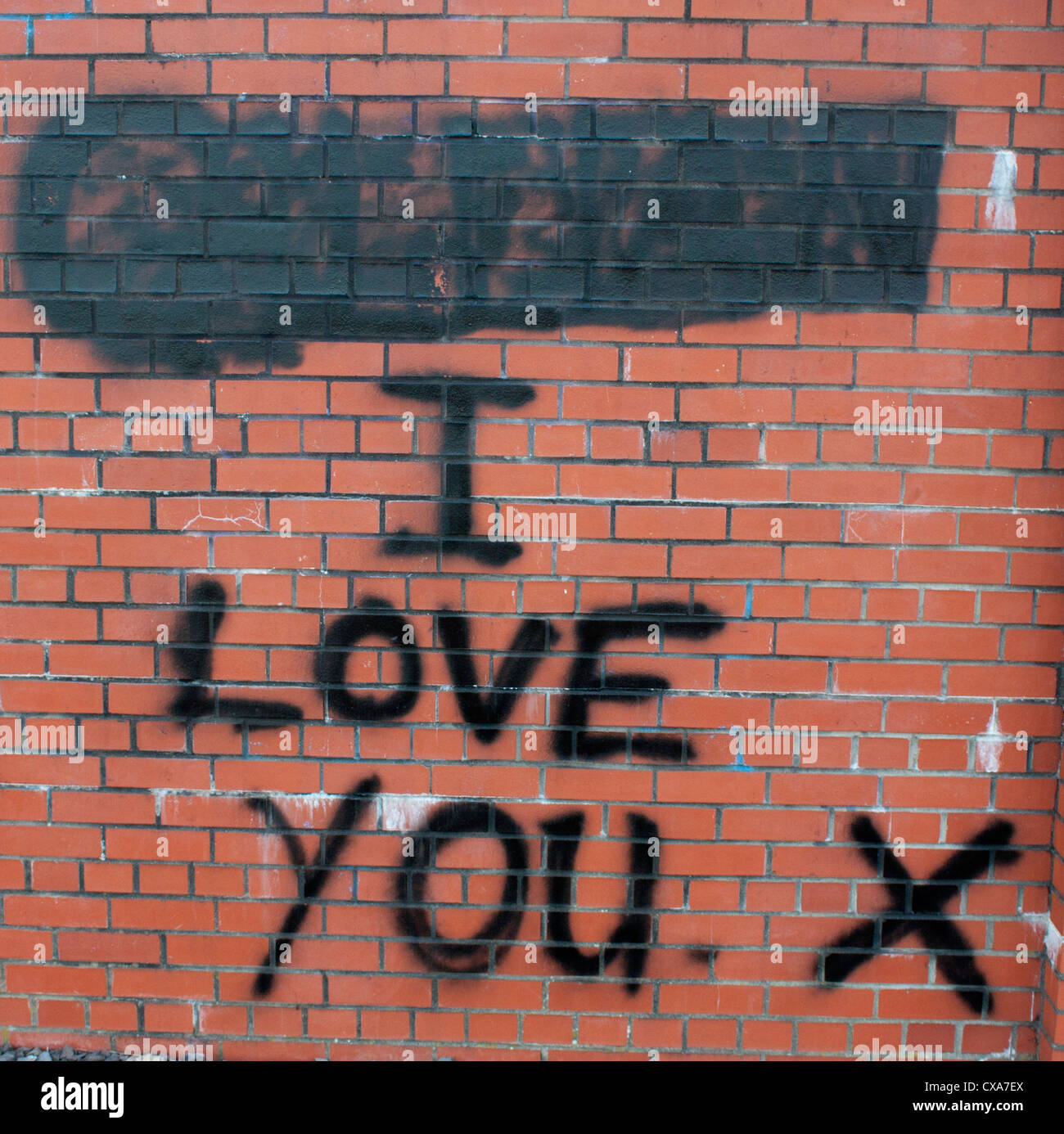 "Ti amo' graffiti rosso sul muro di mattoni con il nome che è al di sopra di dipinti su, indicante il rapporto di break-up Caerphilly Wales UK Foto Stock