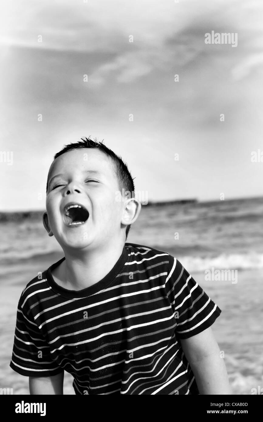 Giovane ragazzo giocando nel parco in un giorno nuvoloso Foto Stock