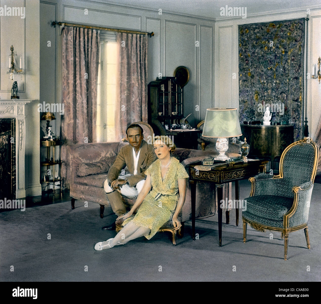 Ritratto colorato di attore, sceneggiatore, regista e produttore americano Douglas Fairbanks (1883 – 1939) e di sua moglie, attrice e produttore americano canadese Mary Pickford (1892 – 1979) seduto accanto al caminetto nel soggiorno della loro proprietà di 18 acri, Pickfair, Beverly Hills, California, 1931. (Foto di Burton Holmes) Foto Stock