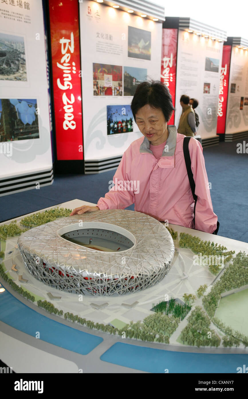 Hong Kong donna guarda a un modello dello stadio olimpico del 2008 Olimpiadi di estate a Pechino Foto Stock