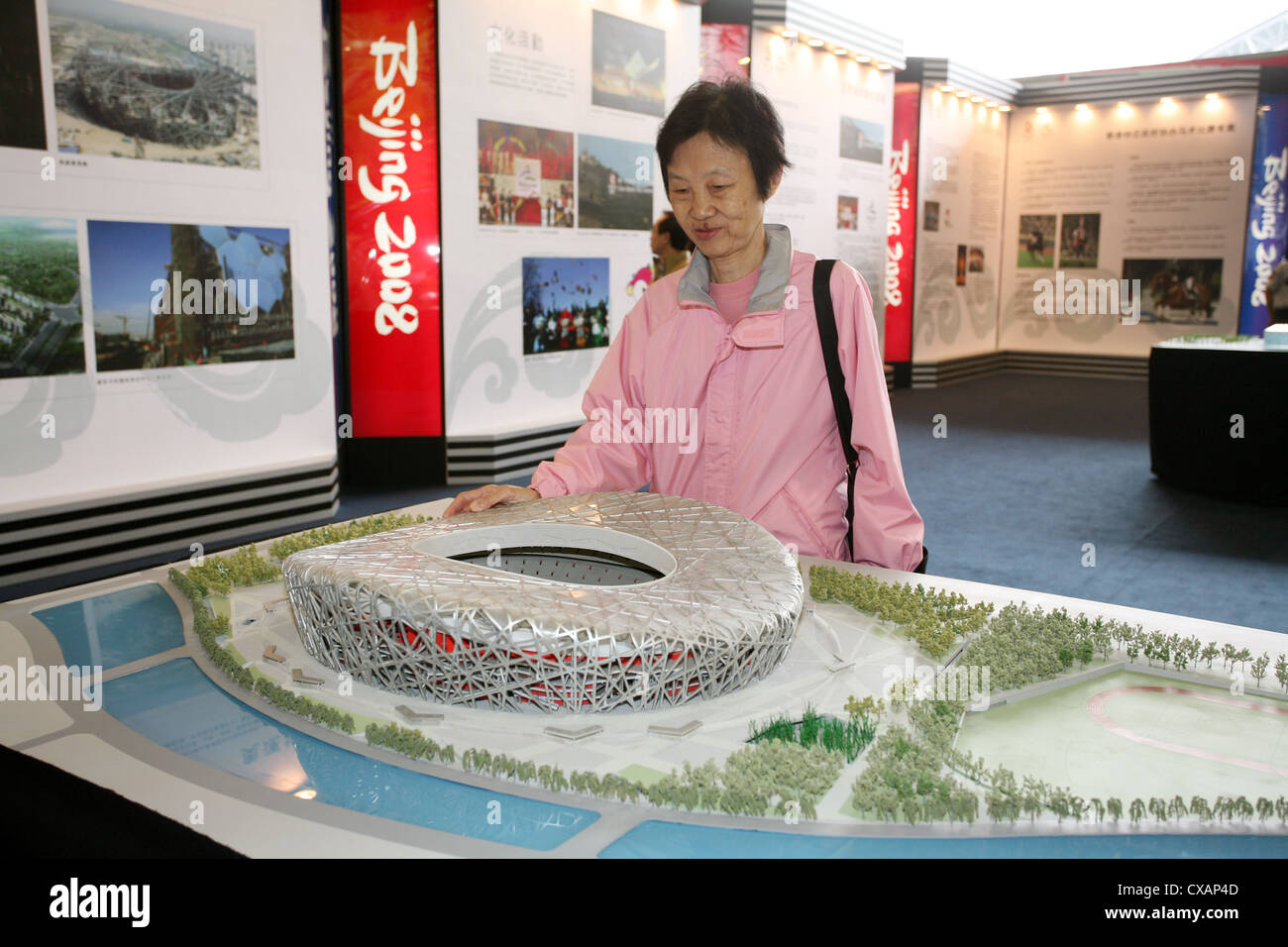 Hong Kong donna guarda a un modello dello stadio olimpico del 2008 Olimpiadi di estate a Pechino Foto Stock