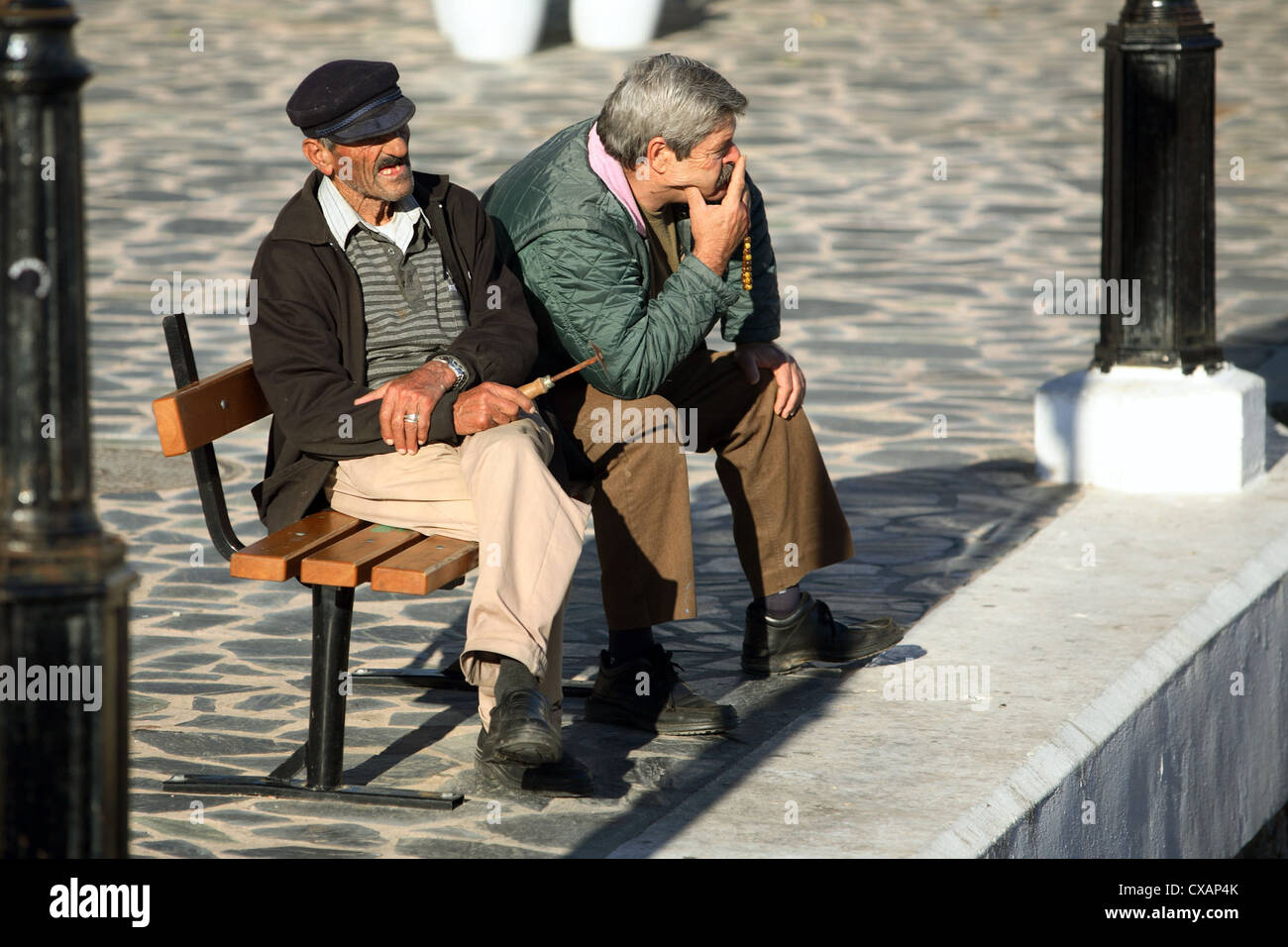 Agios Nikolaos, vecchi uomini seduti su un banco di lavoro Foto Stock