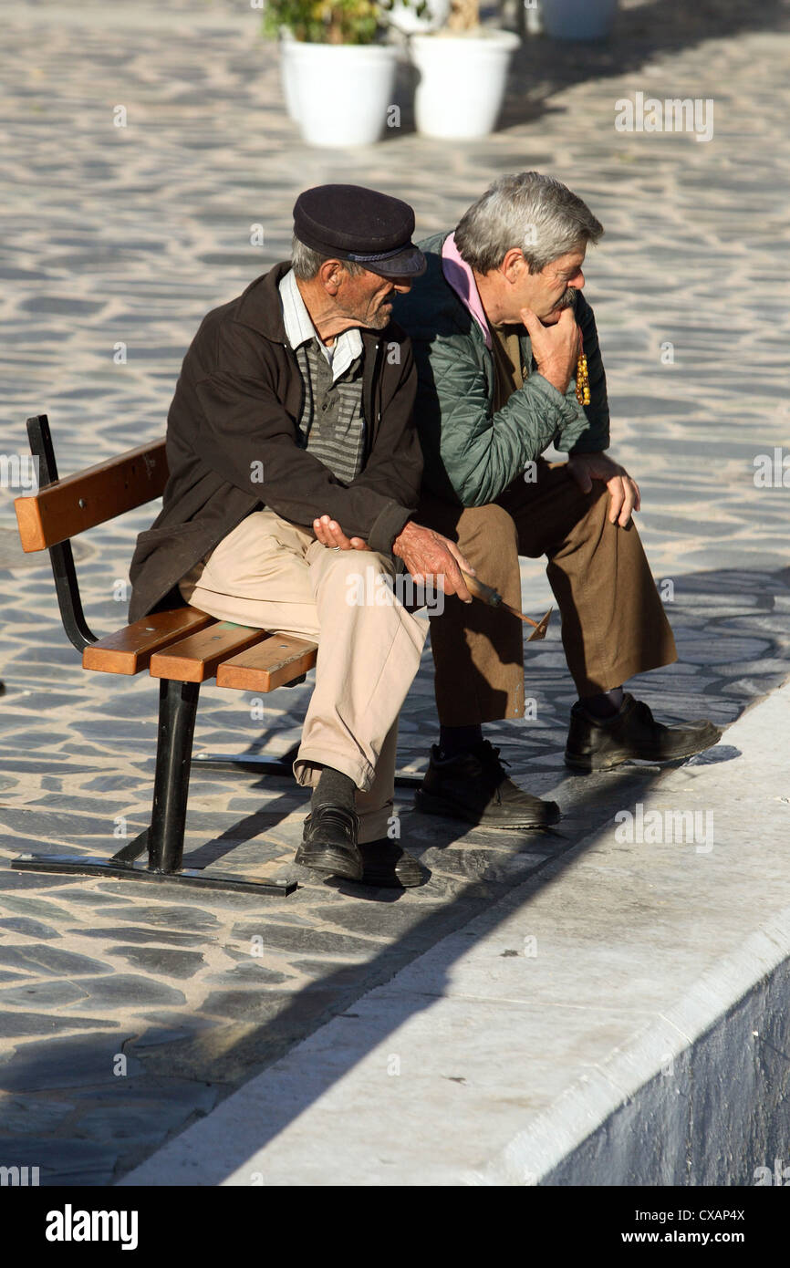 Agios Nikolaos, vecchi uomini seduti su un banco di lavoro Foto Stock