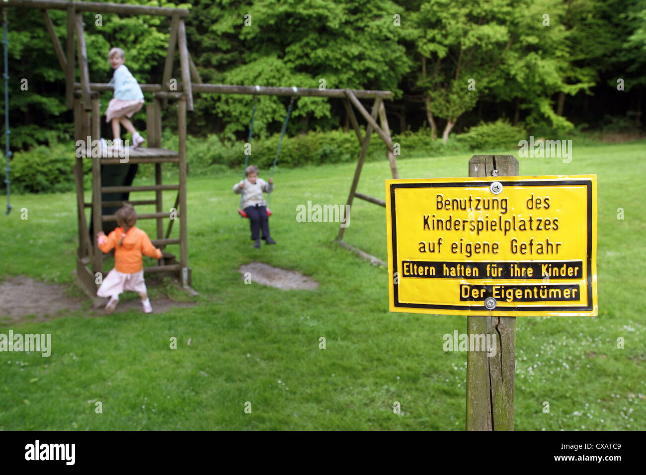 Roedinghausen, bambini su un parco giochi con un segno Foto Stock