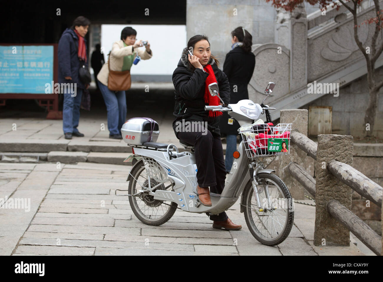 Suzhou, ciclomotore conducente telefonato il suo telefono cellulare Foto Stock