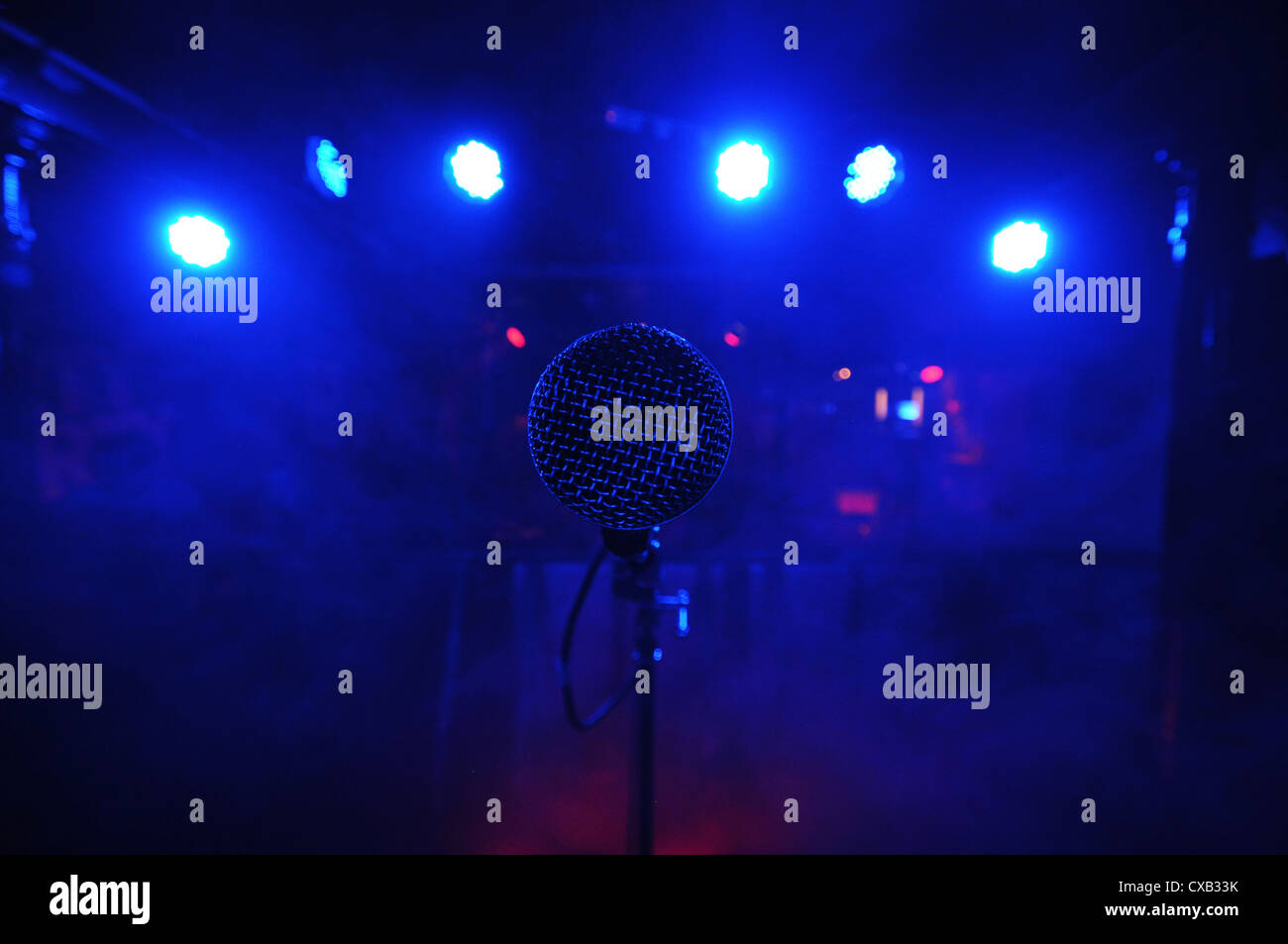 Microfono sul palco con luci blu. Foto Stock