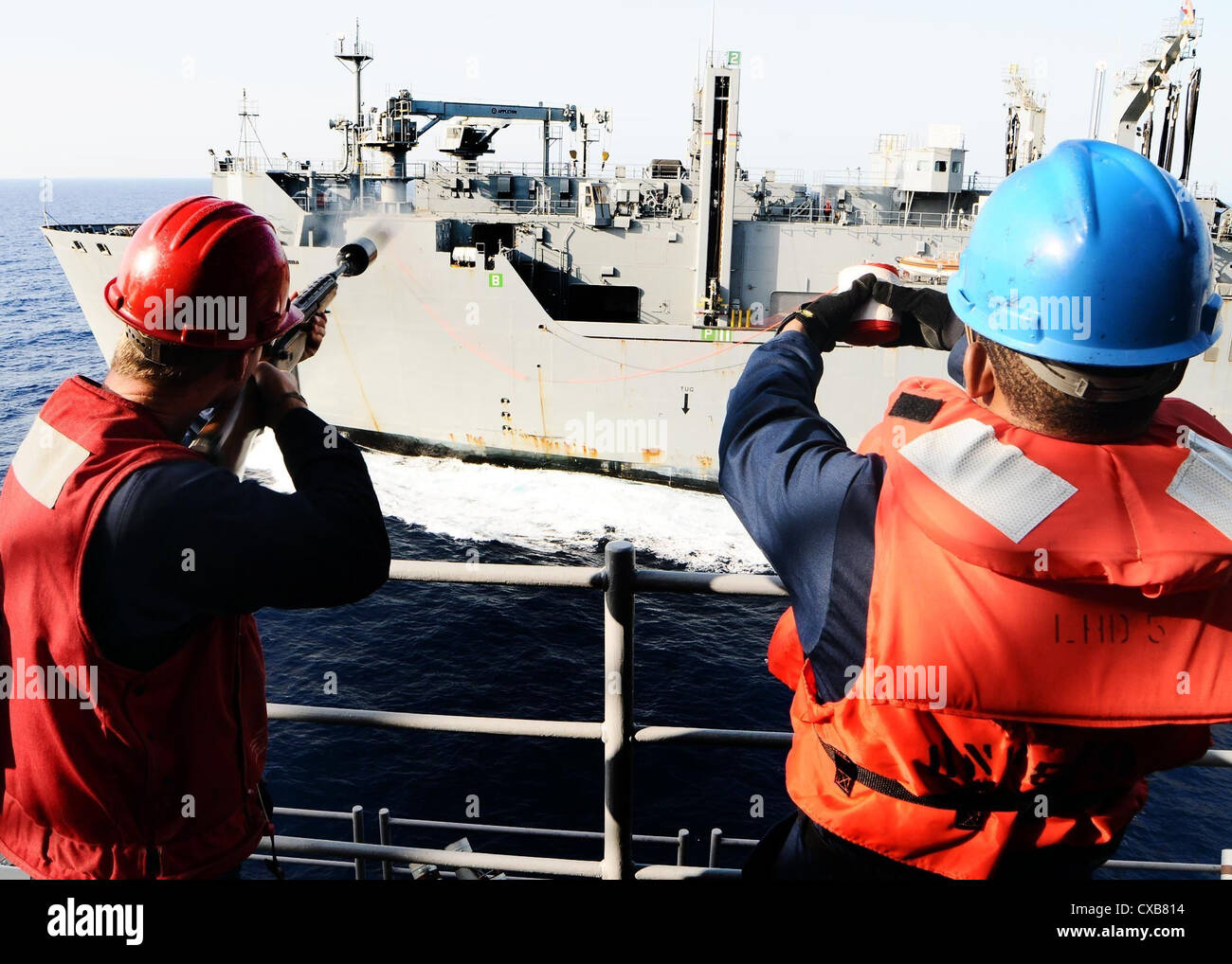 Petty officer di terza classe allen jerrad spara un colpo dalla linea di multipurpose Amphibious Assault nave USS bataan durante un rifornimento in mare con la forza militare di comando sealift carichi secchi e munizioni nave usns robert e. peary. bataan è la nave di comando di bataan amphibious pronto gruppo di supporto le operazioni di sicurezza marittima e di teatro la cooperazione in materia di sicurezza gli sforzi negli Stati Uniti Sesta flotta area di responsabilità. Foto Stock