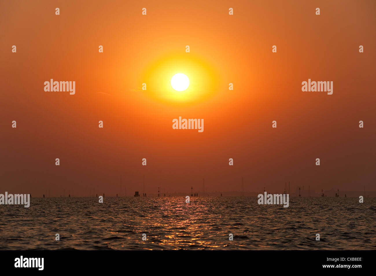 Un tramonto spettacolare mentre il sole tramonta si tuffa in una fogbank sulla laguna veneta, Venezia, Italia Foto Stock