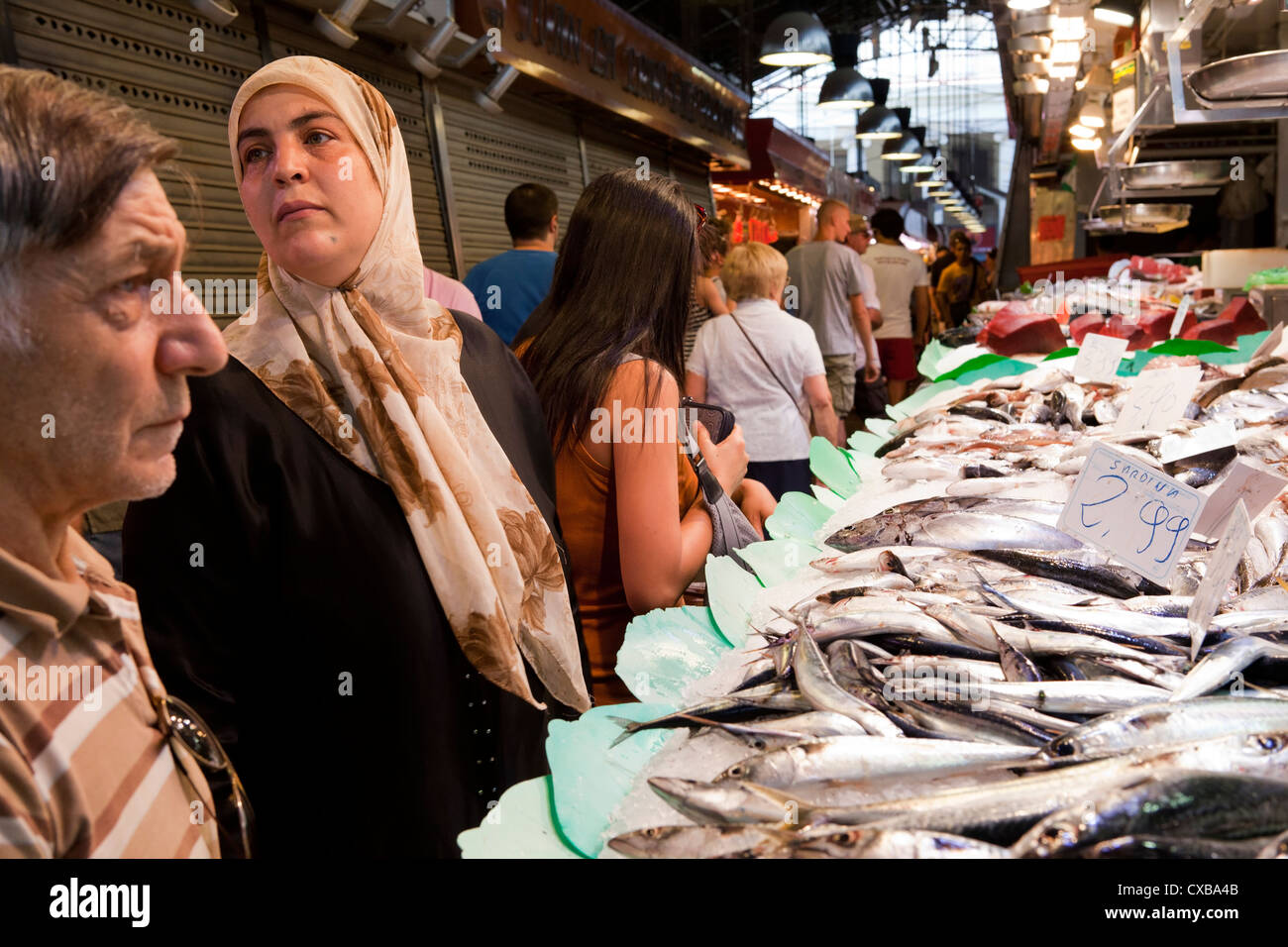 I clienti jockey di prestare attenzione in modo da poter posizionare il loro ordine con il pesce monger nel mercato La Boqueria di Barcellona. Foto Stock