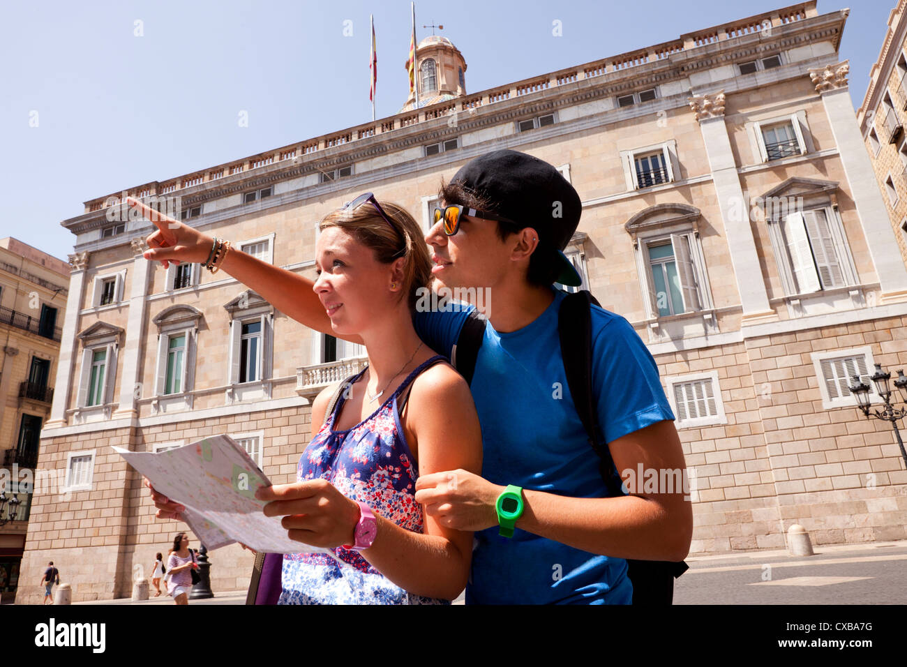 Due turisti italiani utilizzare una mappa per capire il loro prossimo passo come si prendono una pausa dalle visite turistiche di Barcellona. Foto Stock