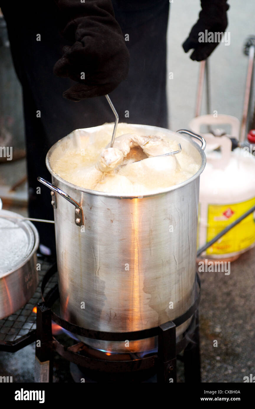 Un tacchino intero essendo fritte in una cucina esterna Foto Stock