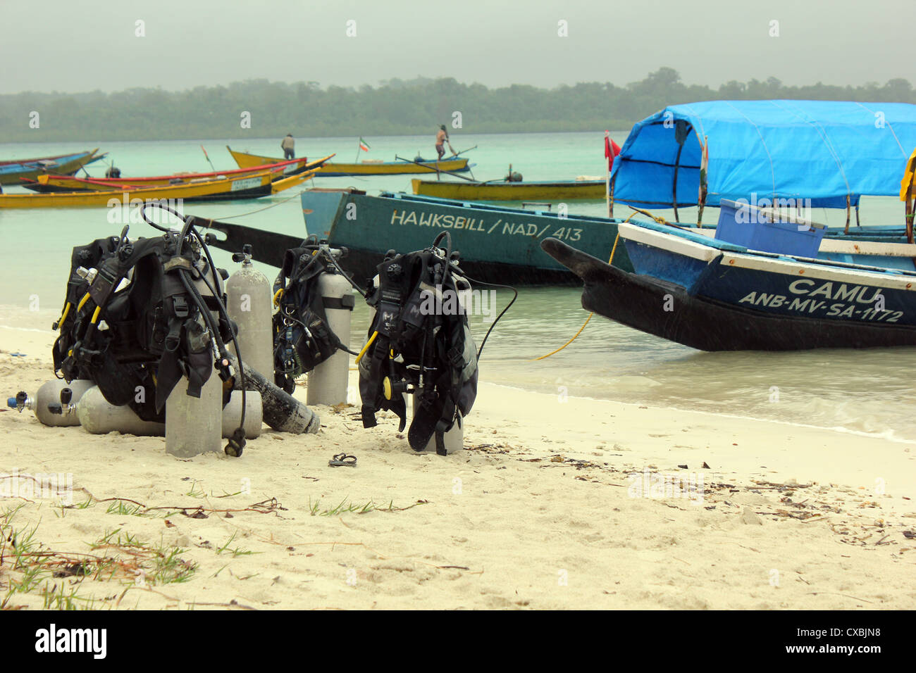 Bombole per immersioni subacquee la lettura per essere caricata su di un battello a Vijayanagar Beach, havelock Island, Andaman Foto Stock