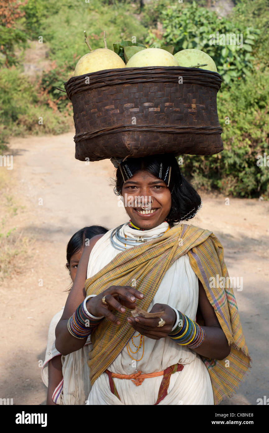 Dunguria Kondh tribeswoman indossando il tradizionale hairgrips tribali e di gioielli recanti paniere di meloni, Bissam Cuttack, Orissa Foto Stock