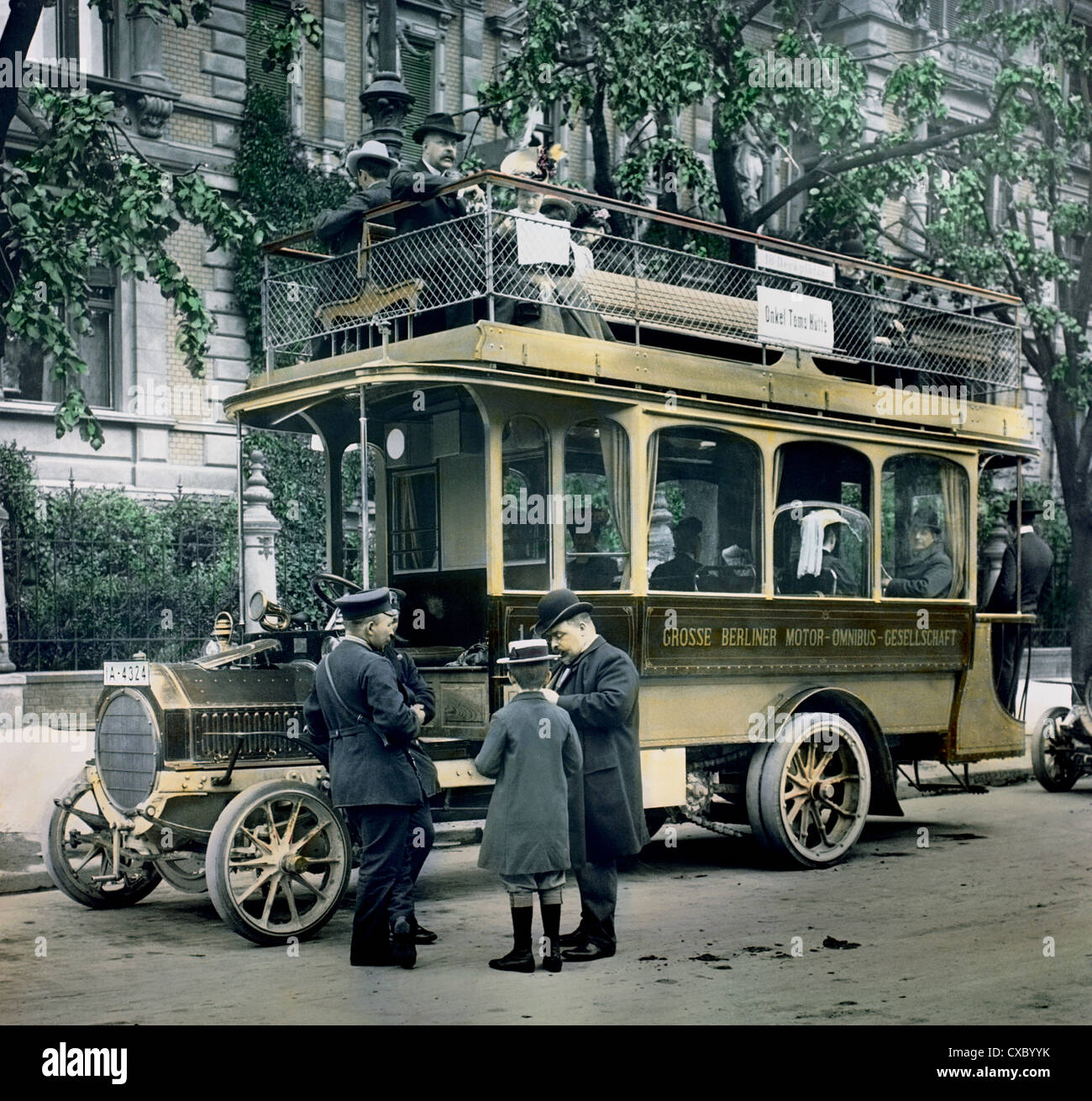 Foto colorata di un conducente di autobus che raccoglie le tariffe di un uomo e di un ragazzo, Berlino, Germania, 1907. Sul lato del bus a due piani è visualizzato ‘Grosse Berliner Motor Omnibus Gesellschaft’ e sopra un cartello per la stazione ‘Onkel Toms Hütte’. (Foto di Burton Holmes) Foto Stock Foto colorata di un conducente di autobus che raccoglie le tariffe di un uomo e di un ragazzo, Berlino, Germania, 1907. Sul lato del bus a due piani è visualizzato ‘Grosse Berliner Motor Omnibus Gesellschaft’ e sopra un cartello per la stazione ‘Onkel Toms Hütte’. (Foto di Burton Holmes) Foto Stock