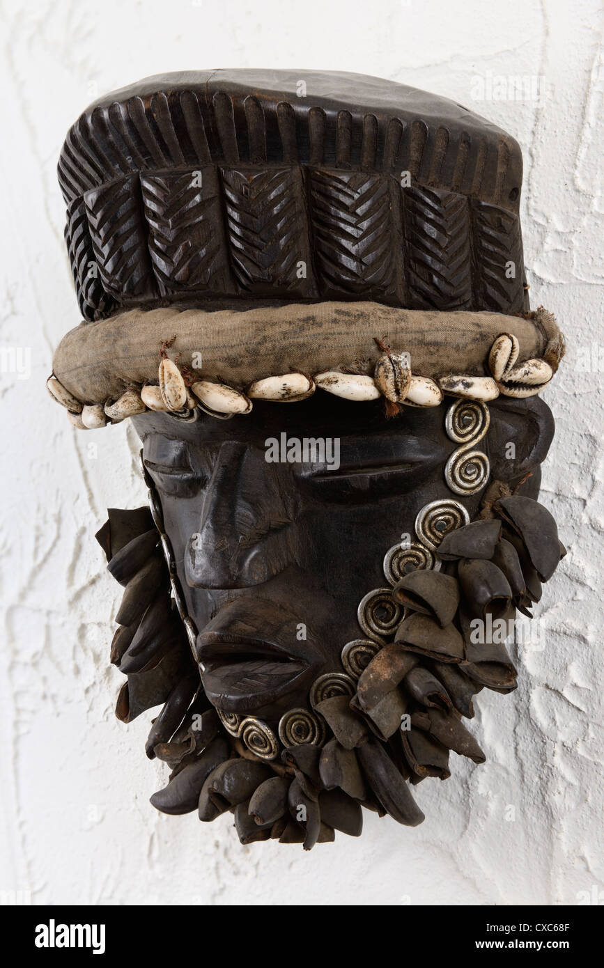 Dan cerimoniale di legno intagliato maschera dalla Costa d Avorio di Africa su un intonaco bianco parete Foto Stock