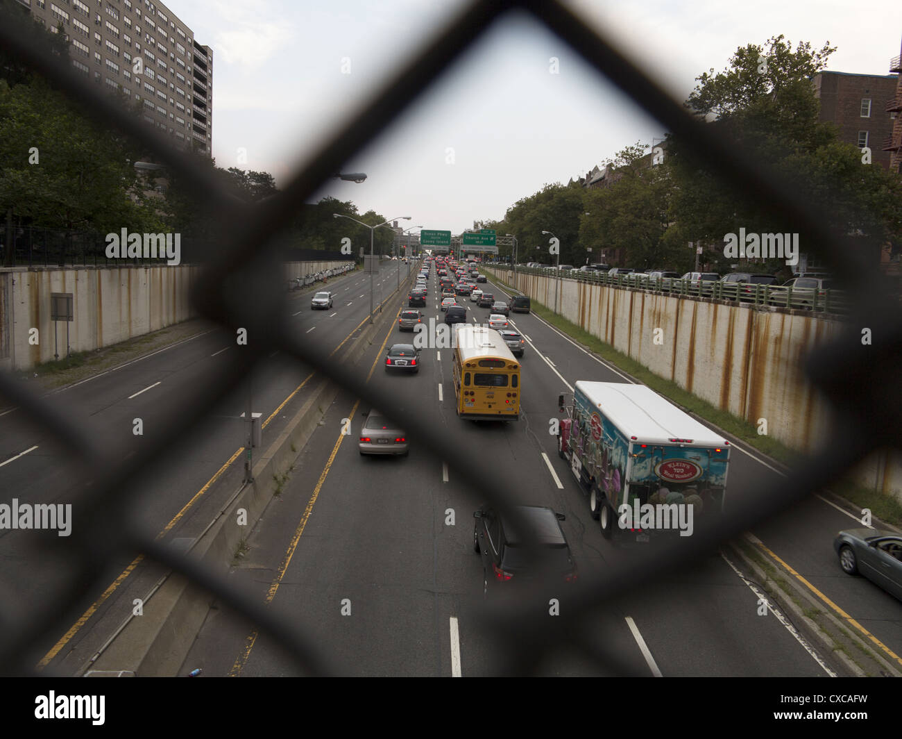 Guardando attraverso una catena collegamento recinto su un ponte al di sopra della prospettiva Expressway in Brooklyn, New York. Foto Stock