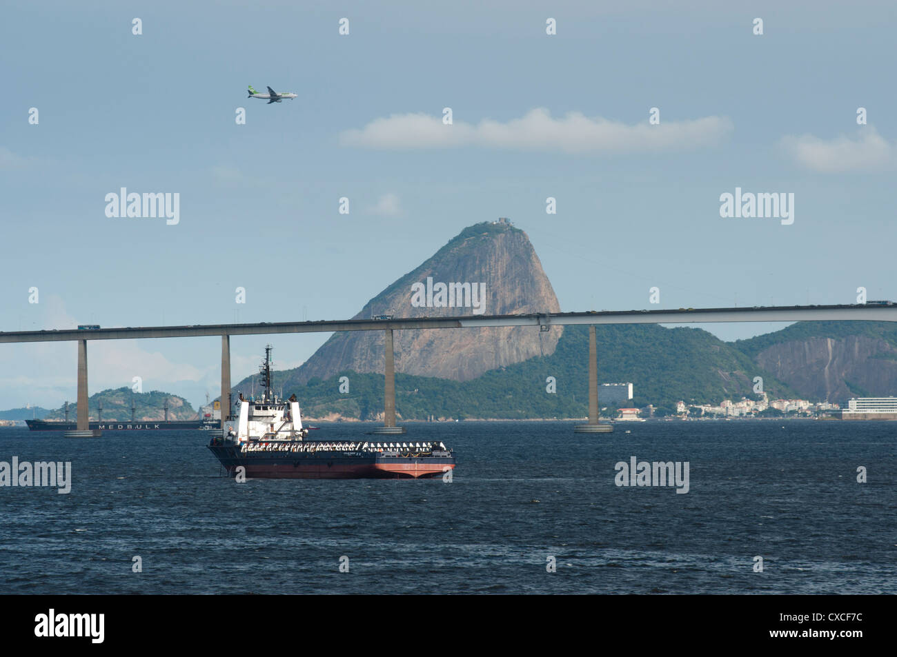 Navi di alimentazione a Baia Guanabara, Rio de Janeiro, aereo in atterraggio a Santos Dummont aeroporto, Sugar Loaf e Rio Niteroi Bridge. Foto Stock