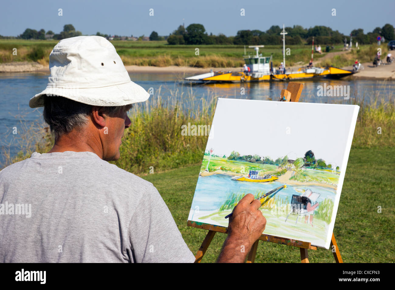 Uomo olandese la pittura la piccola traversata in traghetto del fiume IJssel vicino a Dieren. Paesi Bassi Foto Stock