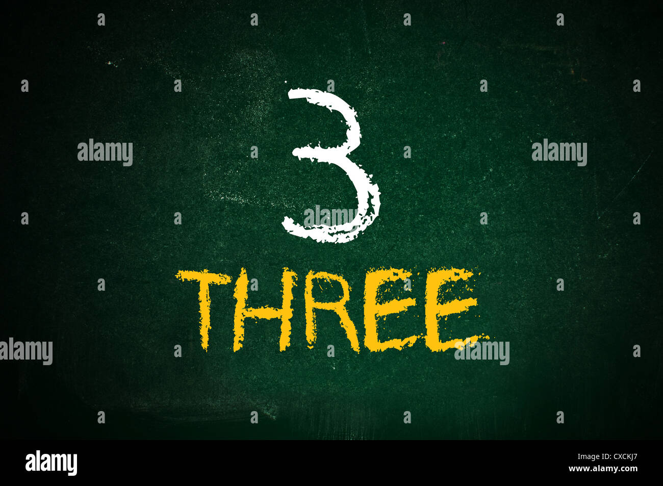 Il numero tre e numero di manoscritti tre con un gesso su una lavagna verde. Foto Stock