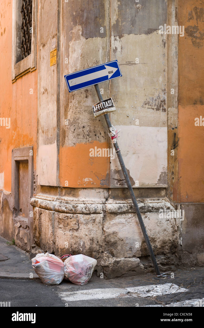 Dettagli della parete, cestino di due sacchi per immondizia e piegate in un modo cartello stradale sulle strade di Roma, Roma, Italia, Italia, Europa Foto Stock