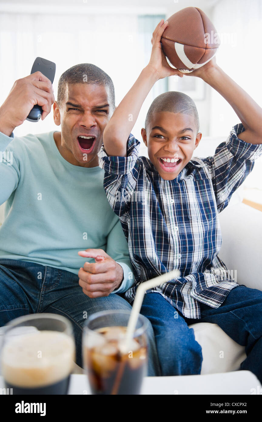 Padre e figlio guardando la partita di calcio in televisione Foto Stock