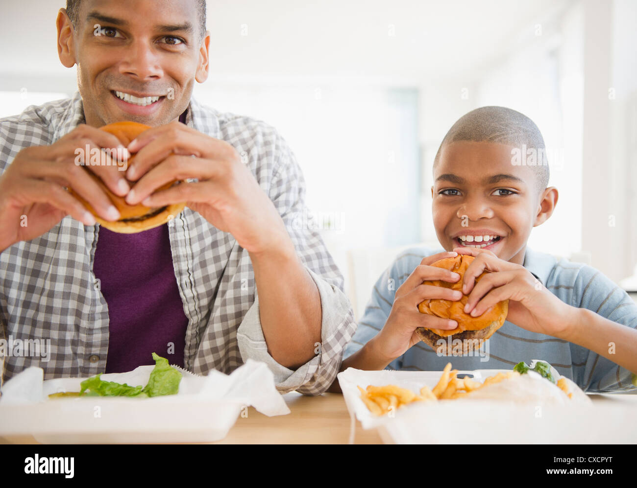 Padre e figlio di mangiare hamburger Foto Stock