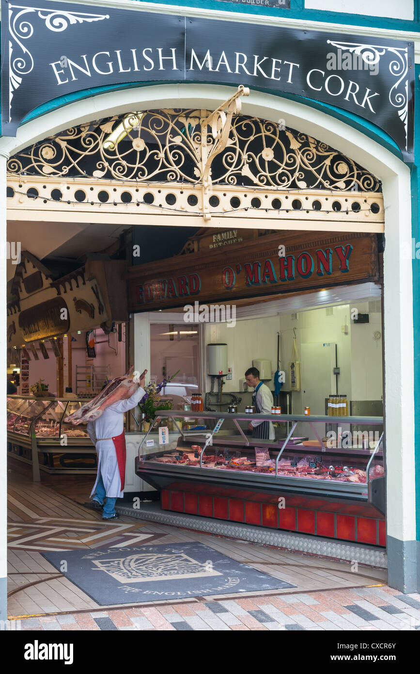 Un macellaio con un agnello intero sopra la sua spalla al mercato inglese, la città di Cork, Repubblica di Irlanda. Foto Stock