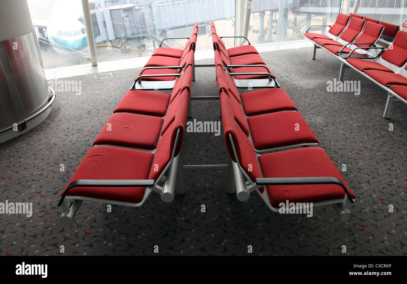 Si tratta di una foto di un intervallo simmetrico di 12 sedi in attesa della partenza o arrivo l'area di un aeroporto internazionale. Nessuno Foto Stock