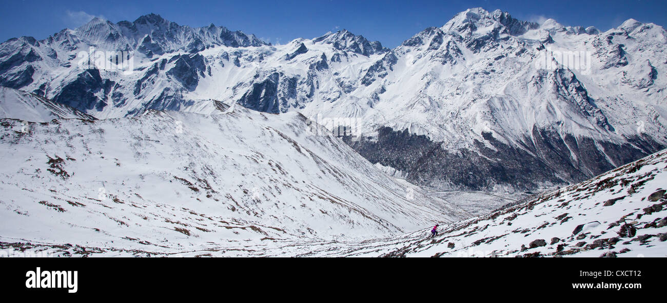 Woman trekking fino al lato di una coperta di neve montagna, Langtang Valley, Nepal Foto Stock