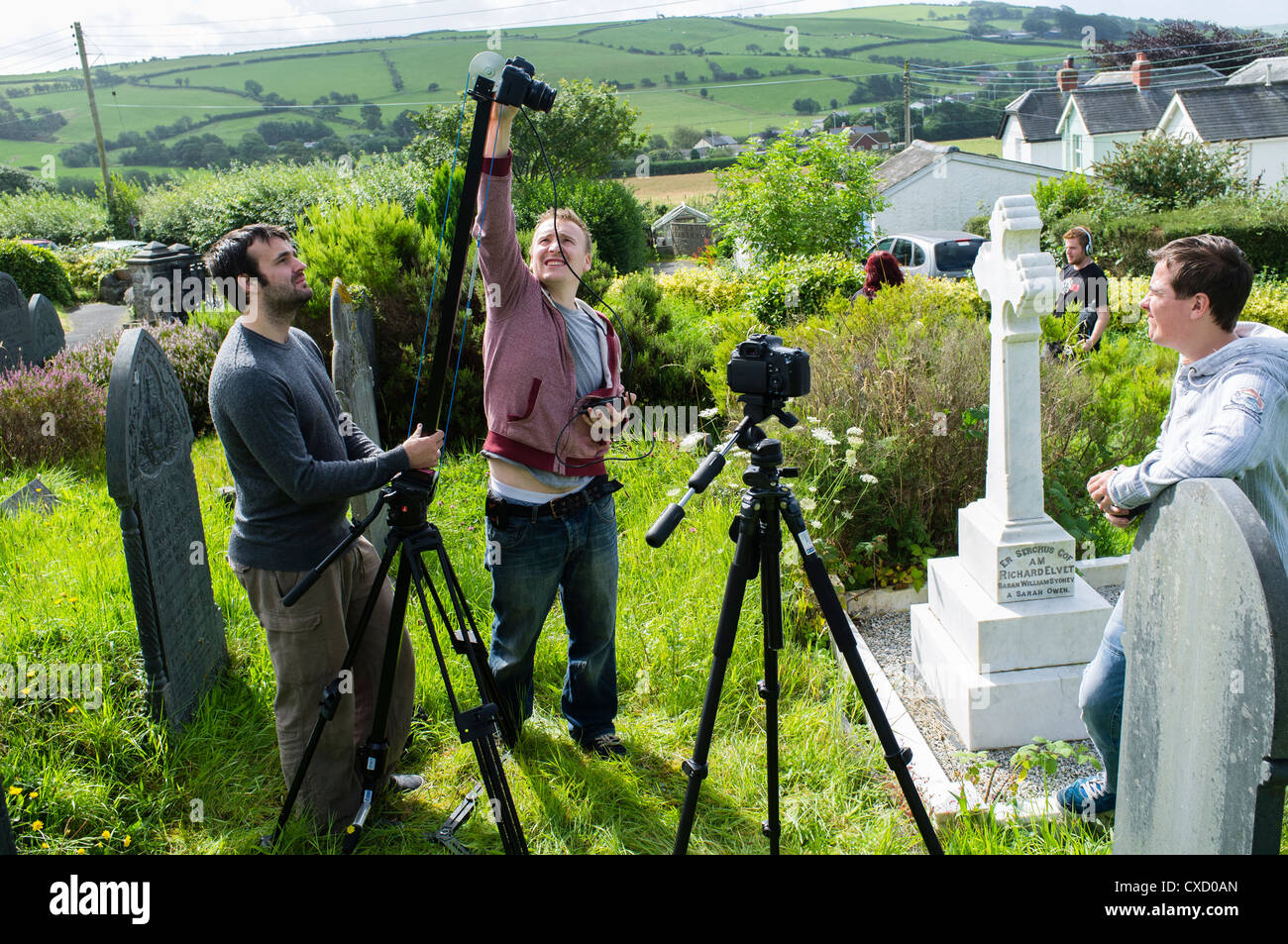 Una piccola troupe cinematografica realizzando un breve film utilizzando Canon DSLR telecamere sulla posizione in un cimitero in West Wales UK Foto Stock