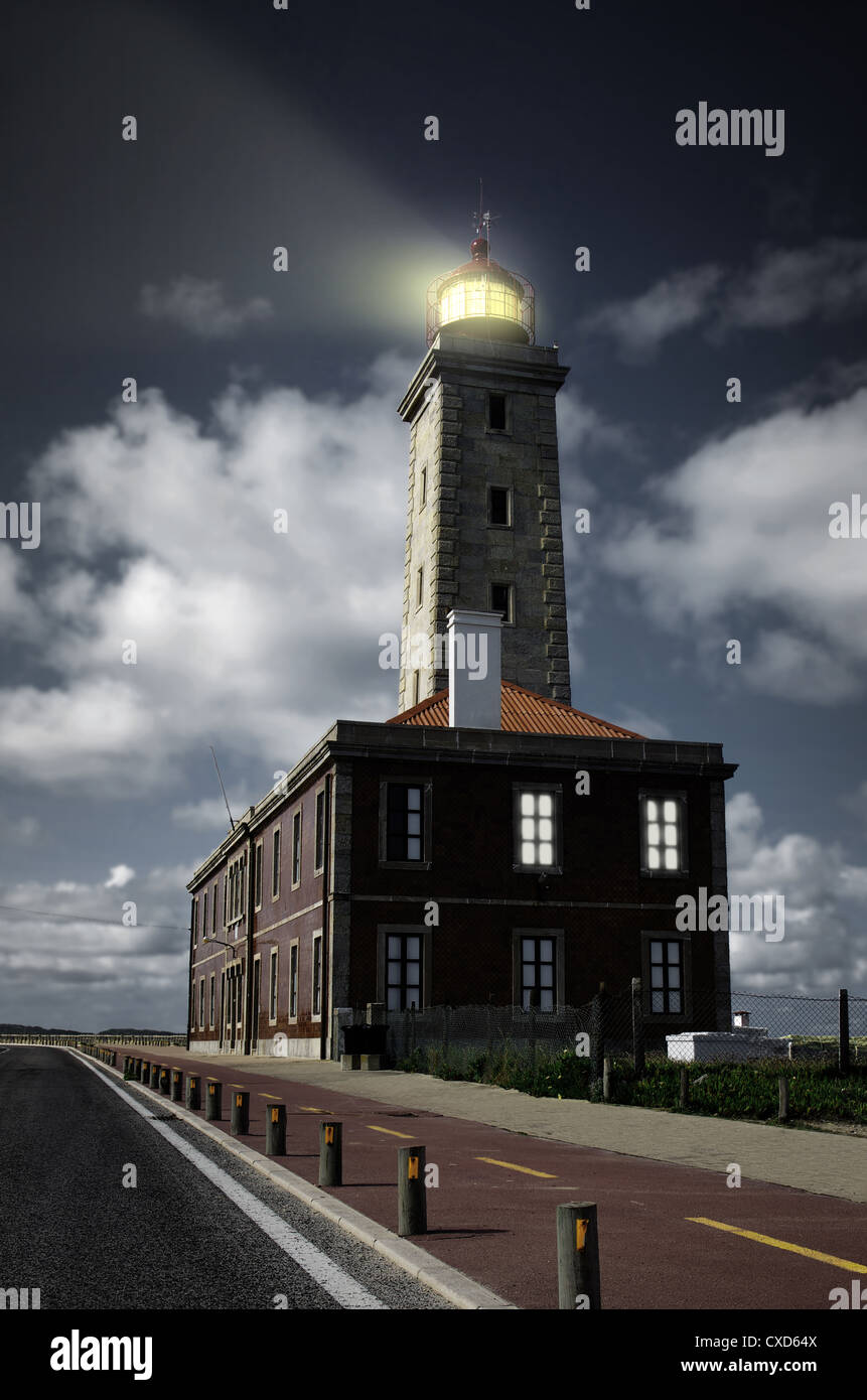 Primo piano su un alto faro con il fascio di luce spazzare il cielo scuro della notte Foto Stock