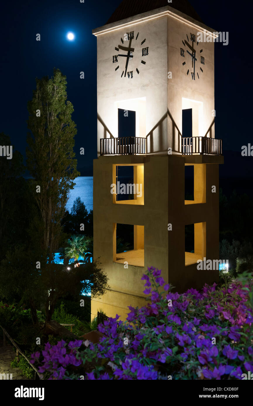 Nana beach resort la torre dell orologio e luna piena con riflessioni sul mare Agios Nikolaos Creta Grecia Foto Stock