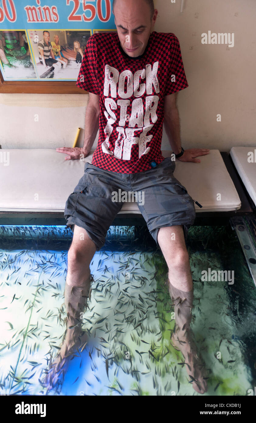 Western tourist avente Garra ruffa sezione terapia sui suoi piedi a Bangkok in Tailandia Foto Stock
