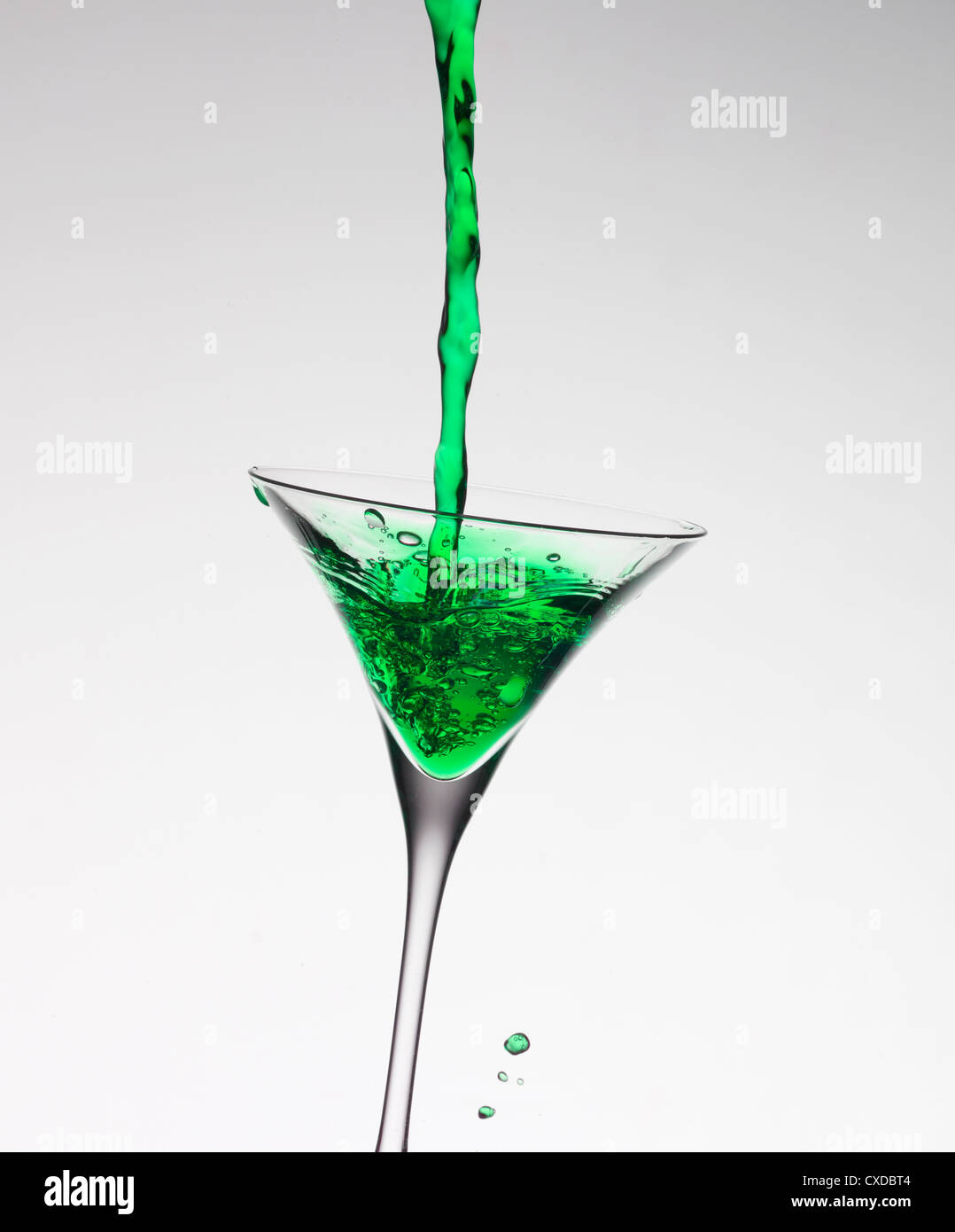 Il verde di riempimento di liquido in vetro martini Foto Stock