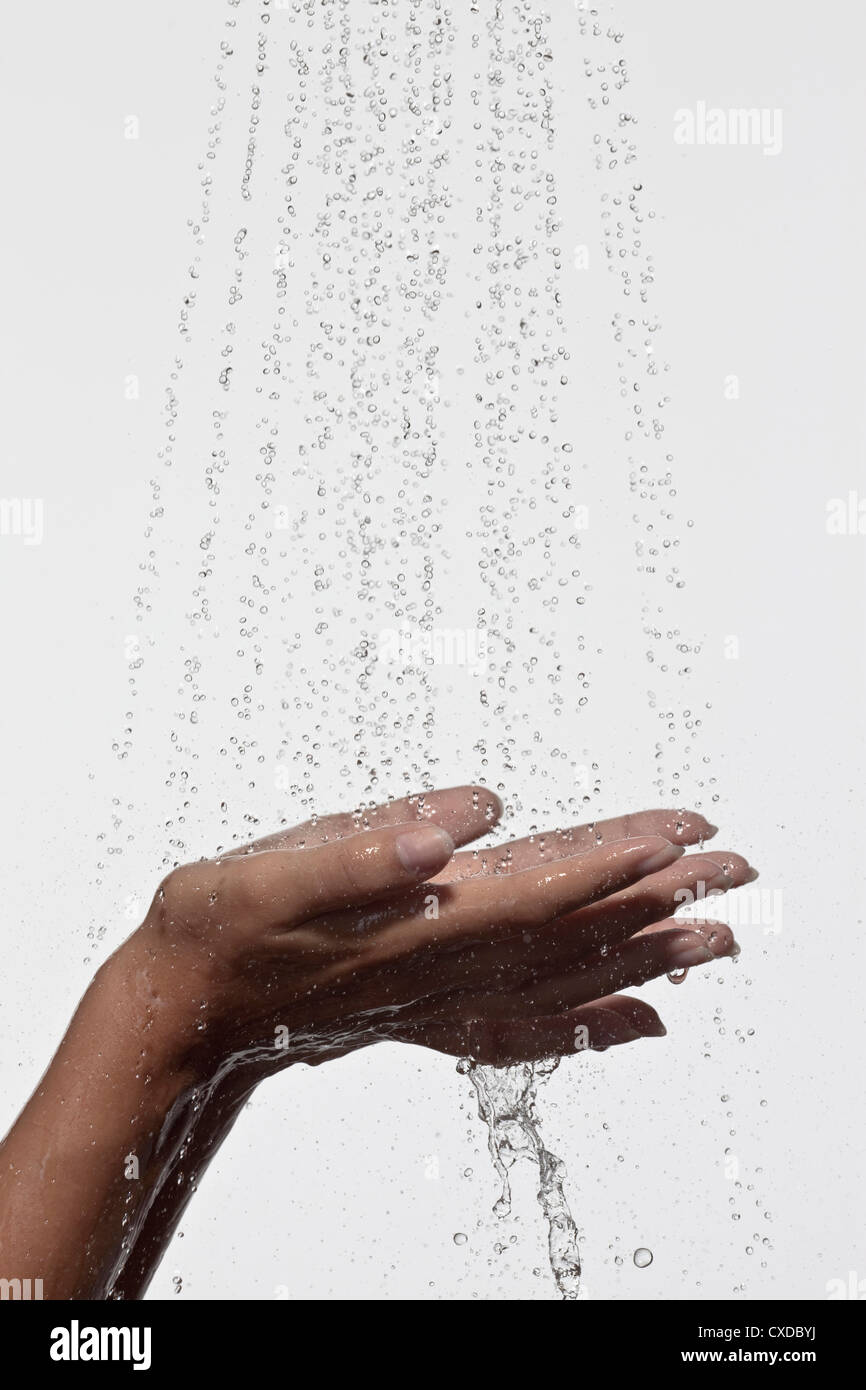 Donna tenendo le mani sotto la doccia Foto Stock