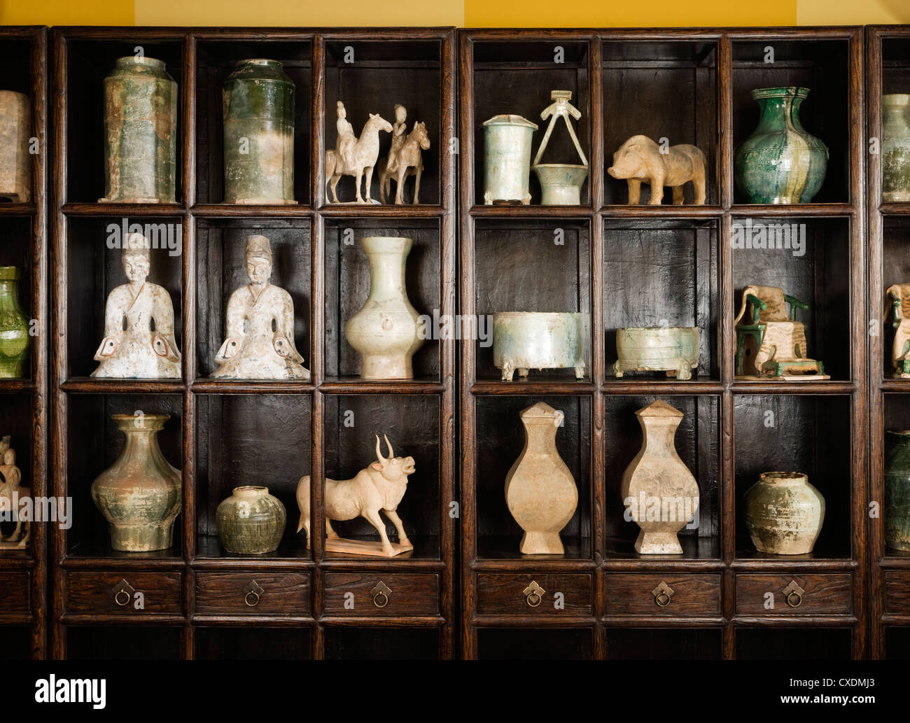 Laccato cinese elm libreria con una raccolta di cinesi Han, Ming e dinastia Qi oggetti Foto Stock