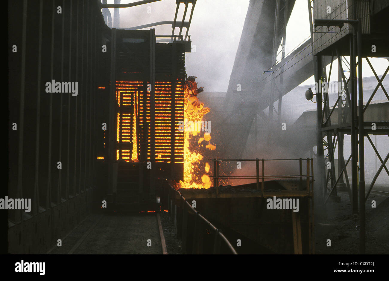 Il coke caldo essendo spinto fuori del forno a coke su opere in acciaio impianto. Foto Stock